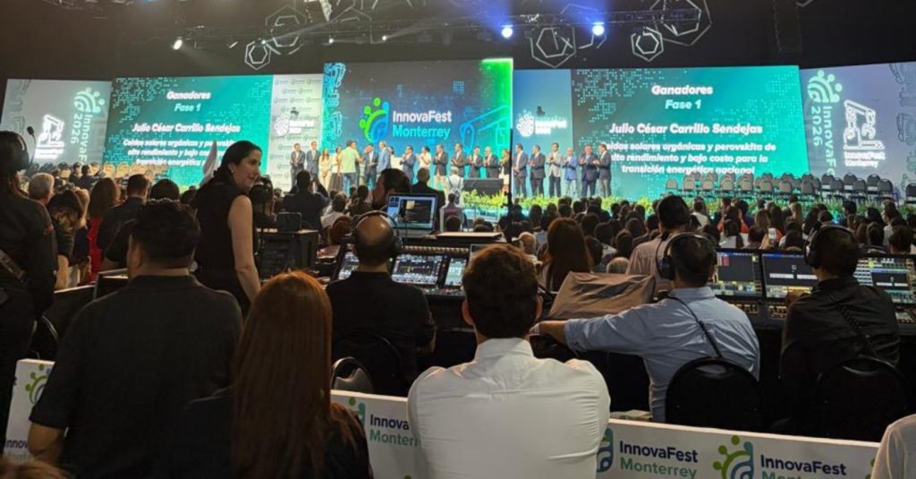 Audience seated in a crowded conference hall watching a stage presentation; large screens read InnovaFest Monterrey and Ganadores Fase 1.